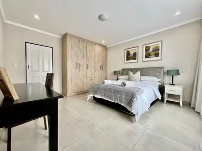 a bedroom with a bed and a desk and a piano at Midrand 2-Bedroom Oasis in Glen Austin in Midrand