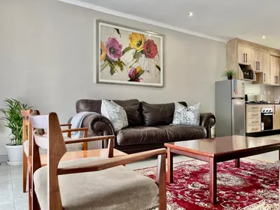 a living room with a couch and a table at Midrand 2-Bedroom Oasis in Glen Austin in Midrand