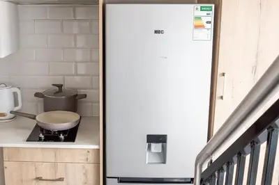 a white refrigerator in a kitchen next to a stove at The Nest in Midrand