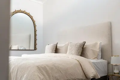 a bedroom with a white bed with a mirror at The Nest in Midrand
