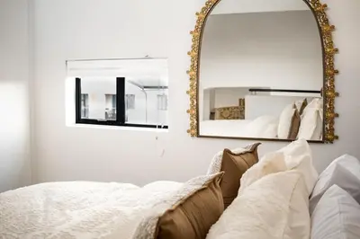 a mirror sitting above a bed in a bedroom at The Nest in Midrand