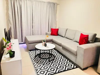 a living room with a gray couch and red pillows at Cozy getaway in Midrand