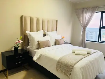 a bedroom with a large bed and a window at Cozy getaway in Midrand