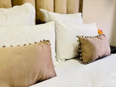 a bed with several pillows on top of it at Cozy getaway in Midrand