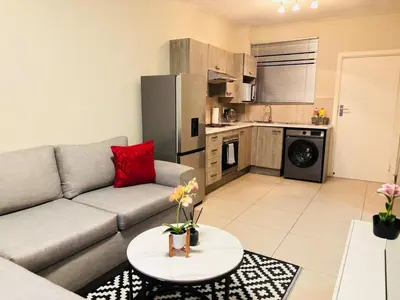 a living room with a couch and a table at Cozy getaway in Midrand