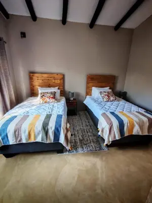 two beds sitting next to each other in a bedroom at Neotha Villa Unit 1 in Marloth Park