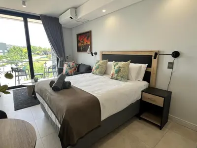 a bedroom with a large bed and a balcony at Entire Apartment in Midrand, South Africa in Midrand