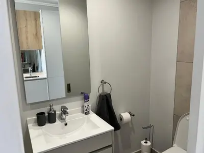 a white bathroom with a sink and a mirror at Entire Apartment in Midrand, South Africa in Midrand