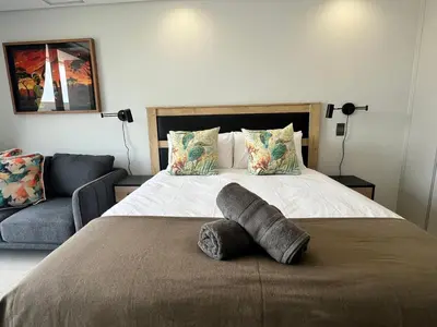 a bedroom with a large bed and a couch at Entire Apartment in Midrand, South Africa in Midrand