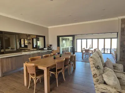 a kitchen and dining room with a wooden table and chairs at Highlands Retreat Lodge In Highland Gate Golf and Trout Estate 1135 in Dullstroom