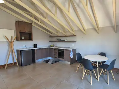 a kitchen with a table and a table and chairs at Highlands Retreat Lodge In Highland Gate Golf and Trout Estate 1135 in Dullstroom