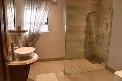 a bathroom with a shower and a sink at Highlands Retreat Lodge In Highland Gate Golf and Trout Estate 1135 in Dullstroom