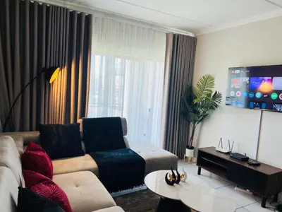 a living room with a couch and a tv at 2 Bed Lux apartment at The Blyde in Pretoria
