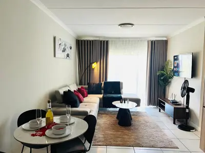 a living room with a couch and a table at 2 Bed Lux apartment at The Blyde in Pretoria