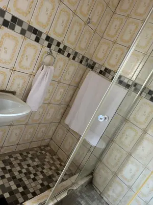 a shower with a glass door next to a sink at Mary's spacious and homely place in Polokwane