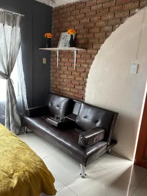 a leather couch in a room with a brick wall at Mary's spacious and homely place in Polokwane