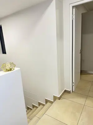 a hallway with a stairway with a white wall at Elusive Haven in Nelspruit