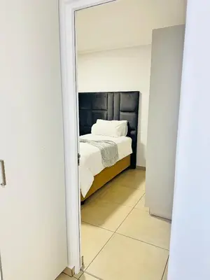a bedroom with a bed viewed through a mirror at Elusive Haven in Nelspruit