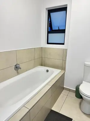 a bathroom with a bath tub and a toilet at Elusive Haven in Nelspruit