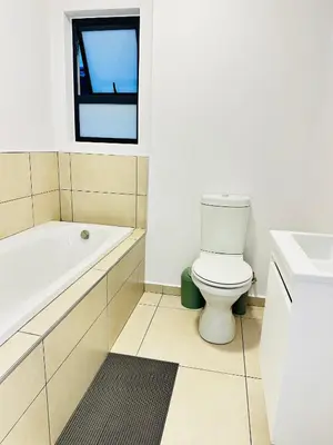 a bathroom with a toilet and a tub and a sink at Elusive Haven in Nelspruit