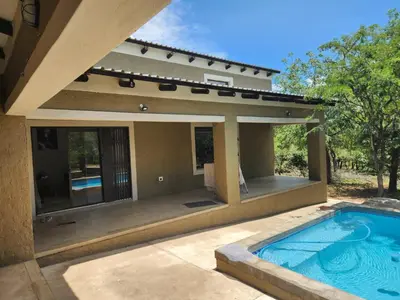 a swimming pool in front of a house at Neotha Villa Unit 2 in Marloth Park