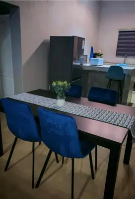 a dining room table with blue chairs at Neotha Villa Unit 2 in Marloth Park