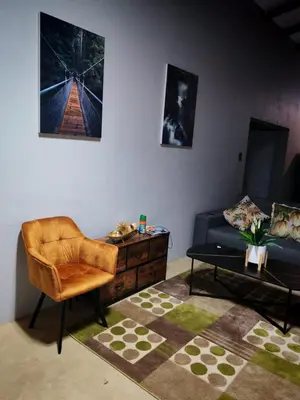 a living room with a couch and a chair at Neotha Villa Unit 2 in Marloth Park