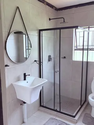 a bathroom with a shower and a sink and a mirror at 43 Home Reyno ridge in Witbank
