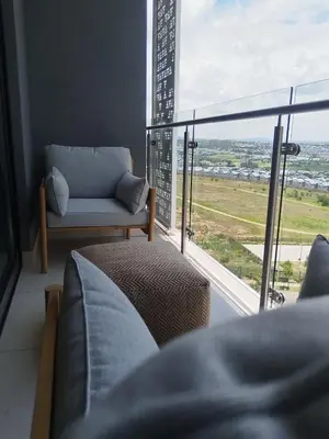 a living room with a couch and a large window at Sunrise Waterfall at ELLIPSE in Midrand