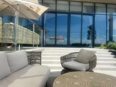 a patio with two chairs and an umbrella at Sunrise Waterfall at ELLIPSE in Midrand