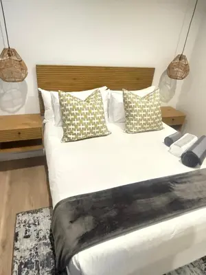 a bedroom with a large white bed with pillows at Sunrise Waterfall at ELLIPSE in Midrand
