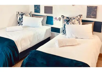 two beds sitting next to each other in a room at Cottage of Grace in Benoni