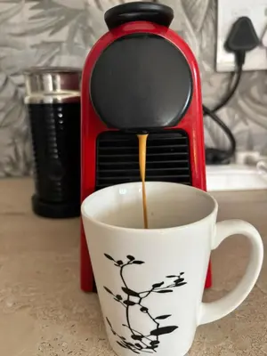 a coffee maker is pouring coffee into a coffee cup at Cottage of Grace in Benoni