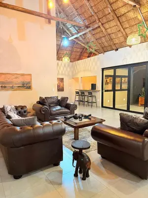 a living room with leather furniture and a table at Fikani game lodge in Thabazimbi