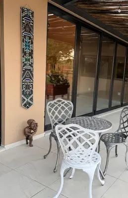 a teddy bear sitting next to a table and chairs at Fikani game lodge in Thabazimbi