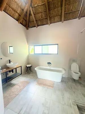 a bathroom with a tub and a toilet and a sink at Fikani game lodge in Thabazimbi
