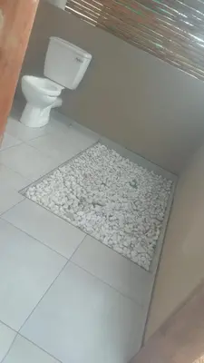 a bathroom with a toilet and a stone floor at Fikani game lodge in Thabazimbi