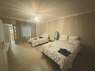 a bedroom with two beds and a light at VinVid Harties Guest House in Hartbeespoort