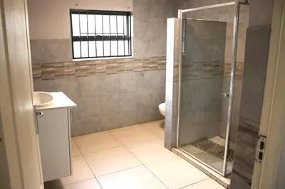 a bathroom with a shower and a sink at VinVid Harties Guest House in Hartbeespoort
