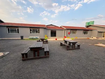a group of picnic tables in a parking lot at VinVid Harties Guest House in Hartbeespoort