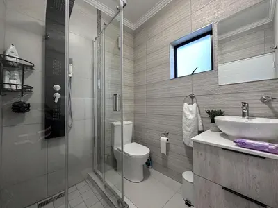 a bathroom with a toilet and a sink and a shower at Indulge in Elegance & Comfort in Midrand