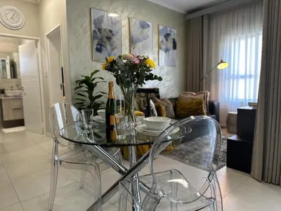 a glass table with a vase of flowers in a living room at Indulge in Elegance & Comfort in Midrand