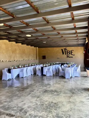 a banquet hall with white tables and white chairs at The Vibe Venue in Pretoria