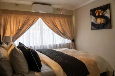 a bedroom with a bed and a window at 10 Kooralboom Self Catering Apartments in Nelspruit