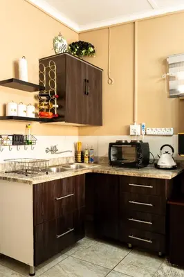 a kitchen with a sink and a microwave at 10 Kooralboom Self Catering Apartments in Nelspruit