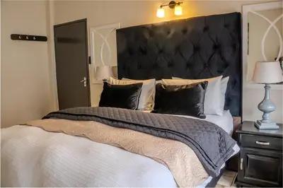 a bedroom with a large bed with a large black headboard at 10 Kooralboom Self Catering Apartments in Nelspruit