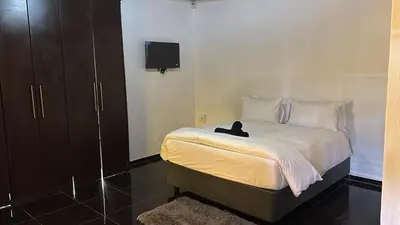 a bedroom with a bed with a black cat sitting on it at BTV Villa in Hazyview