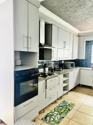 a kitchen with white cabinets and a blue stove top oven at BTV Villa in Hazyview