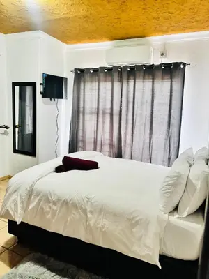 a bedroom with a white bed and a window at BTV Villa in Hazyview