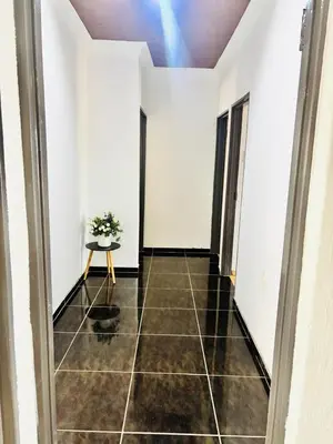 a hallway with white walls and a table with a plant at BTV Villa in Hazyview